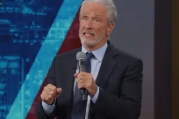 Jon Stewart speaking on a late-night stage