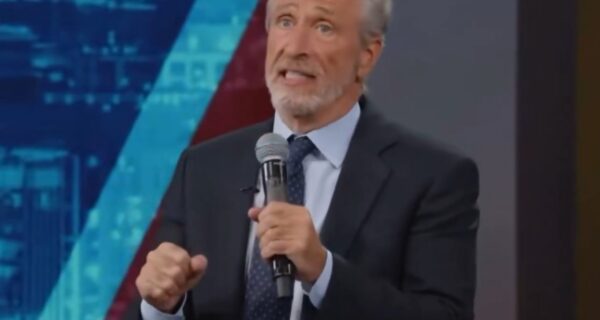 Jon Stewart speaking on a late-night stage