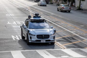 Waymo robotaxi on a California street near emergency scene