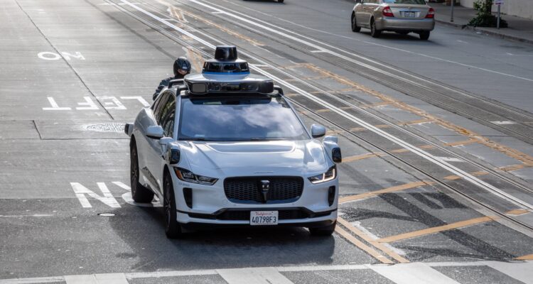 Waymo robotaxi on a California street near emergency scene