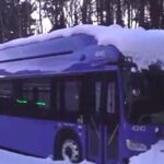 Parked electric buses covered in snow