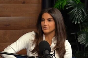 Kaitlan Collins speaking on a podcast microphone