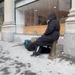 Stretch of NYC street with a warming center sign and snow on the ground
