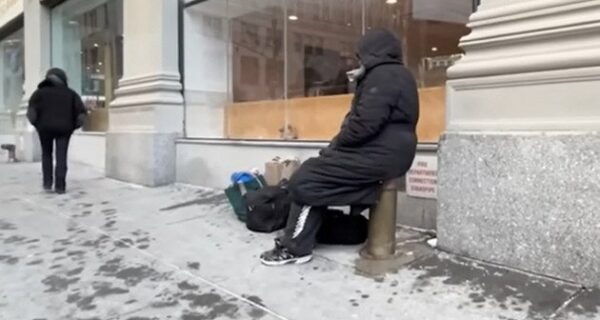 Stretch of NYC street with a warming center sign and snow on the ground