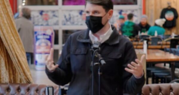 James Talarico speaking while wearing a mask