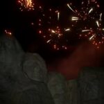 Mount Rushmore at dusk with fireworks in the sky