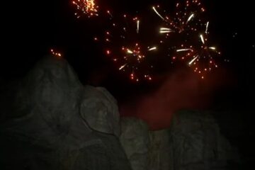 Mount Rushmore at dusk with fireworks in the sky