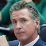 Gavin Newsom speaking at a podium in California