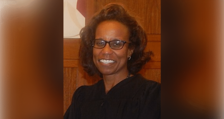 Federal judge ruling on an election case with a voting sign in the background