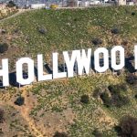 Hollywood sign with a film industry discussion about productions leaving Los Angeles