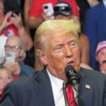 Donald Trump raises his fist after the Butler Pennsylvania assassination attempt with blood on his face