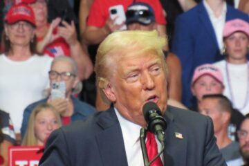 Donald Trump raises his fist after the Butler Pennsylvania assassination attempt with blood on his face