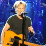 John Mellencamp performing on stage during a concert