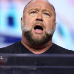 Alex Jones celebrates a Texas appeals court ruling reducing the punitive damages in a Sandy Hook case
