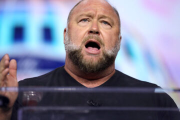 Alex Jones celebrates a Texas appeals court ruling reducing the punitive damages in a Sandy Hook case