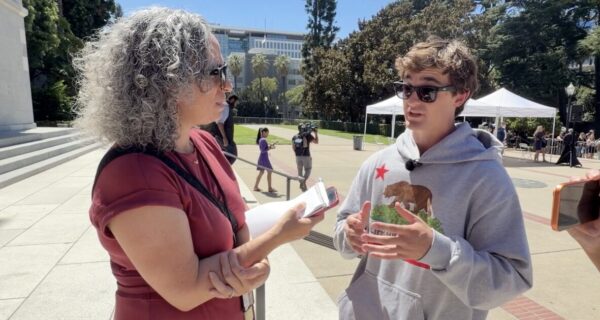 Nick Shirley speaks with New York Times reporter Laurel Rosenhall outside the California State Capitol