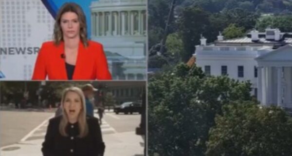 A man heckles CNN reporter Betsy Klein outside the White House during a live segment