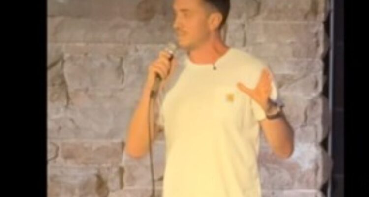 Mike Hammock performing a comedy set while discussing Lindsay Clancy supporters