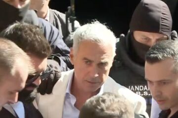 Călin Georgescu escorted in handcuffs after a Romanian police raid