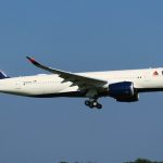 Police escort a disruptive Delta passenger off an aircraft before takeoff at JFK Airport