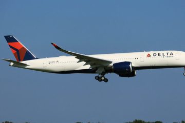 Police escort a disruptive Delta passenger off an aircraft before takeoff at JFK Airport