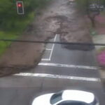 Flash floodwaters sweep cars through a street in Santiago, Chile, after heavy rain.