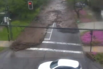 Flash floodwaters sweep cars through a street in Santiago, Chile, after heavy rain.