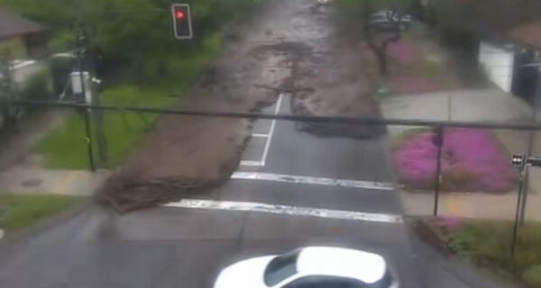 Flash floodwaters sweep cars through a street in Santiago, Chile, after heavy rain.