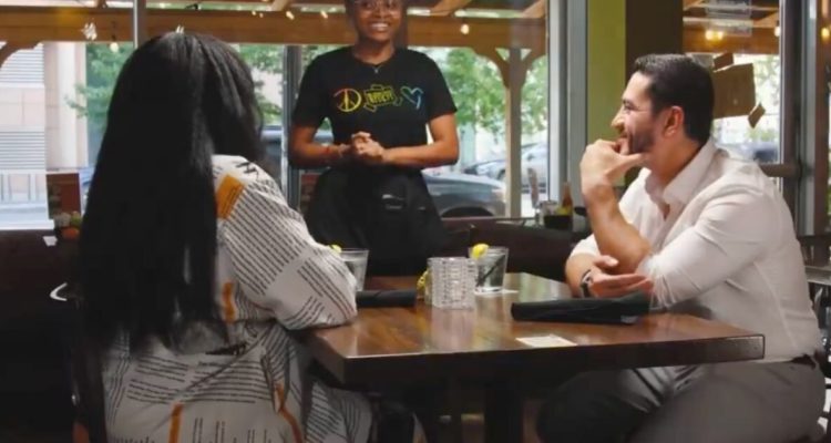 Abdul El-Sayed sits with a Black woman at a restaurant during a voter outreach video
